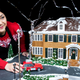 Cake artist poses with complete McCallister house